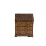 A GEORGE III MAHOGANY AND WALNUT GENTLEMAN'S BUREAU, the sloped drop front opening to reveal a