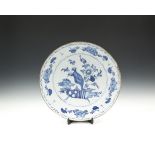 A LARGE DUTCH DELFT DISH, 18th century, of deep circular form, the centre painted with still life