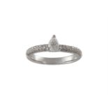 A DIAMOND DRESS RINGCentrally highlighted by a three claw-set pear shaped diamond, between pavé-