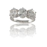 A DIAMOND THREE-STONE RINGSet with a trio of old-cut diamonds, the central old cushion-shaped