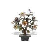 A 20TH CENTURY JAPANESE COLOURED HARDSTONE MODEL OF A BONSAI TREE, set in a polished stone