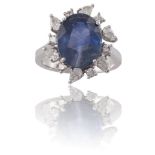 A SAPPHIRE AND DIAMOND CLUSTER RINGThe oval-shaped sapphire, weighing 8.19cts, within a surround