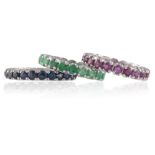 A SET OF THREE FULL HOOP ETERNITY RINGSEach set with circular-cut emeralds, rubies or sapphires