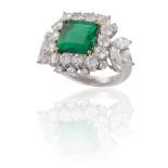 AN EMERALD AND DIAMOND DRESS RINGThe square step-cut emerald, weighing approximately 3.50cts, within