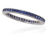 A SAPPHIRE FULL HOOP ETERNITY RINGChannel-set with a line of calibré-cut blue sapphires, mounted