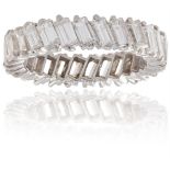 A DIAMOND ETERNITY RINGComposed of a continuous row of baguette-cut diamonds, each in a two-claw