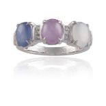 A STAR SAPPHIRE THREE-STONE RINGSet with a trio of colourless, pink and blue oval-shaped cabochon