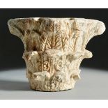 Capitel romano en piedra tallada, con una Menorah o candelabro tallado en uno de sus lados. hojas