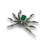 Broche araña Art-Decó con centro de esmeralda ,patas con esmeraldas y ojos de rubí. En oro de 18K