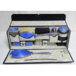 178. A George V silver & blue enamelled backed ten piece travelling toilet set in fitted navy blue