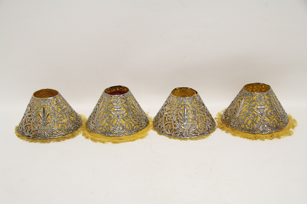A set of four Gorham Co. sterling pierced conical lamp shades decorated with anthemions, urns,