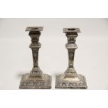 A pair of late Victorian Adam style candlesticks with square tapered columns & on square bases,