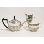 An Edwardian three-piece tea service of oval semi-fluted design; London 1905, by Goldsmiths &