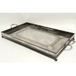 A Victorian rectangular two-handled tea tray with engraved borders, pierced gallery, & on claw-feet;