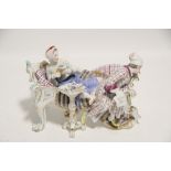 A continental porcelain male & female figure costume figure group, the couple on a rococo style bed,