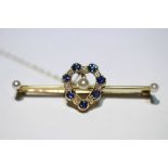 A 15ct. gold bar brooch, the open heart-shaped centre set sapphires, diamonds, & three small