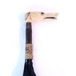 An early 20th century umbrella with carved ivory greyhound head handle & with yellow-metal mounts; &