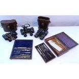 Three pairs of field glasses, two with case; and two matched sets of drawing instruments, each