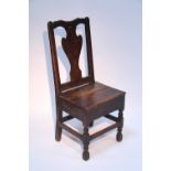 An 18th century oak side chair with shaped solid splat to the open back, the hard seat fitted