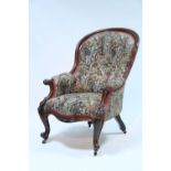 A mid-Victorian ‘spoon-back’ armchair, the carved mahogany frame with scroll arms & on cabriole