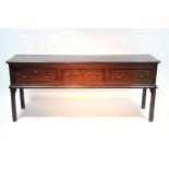 An 18th century mahogany dresser base fitted three drawers with brass swan-neck handles, on square