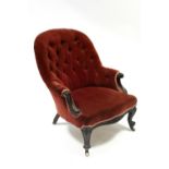 A mid-Victorian carved rosewood frame armchair upholstered crimson velour, with rounded buttoned