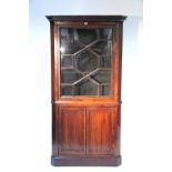 A late 18th century mahogany standing corner cabinet with two shaped shelves enclosed by an astragal