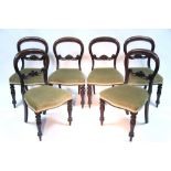 A set of six mid-Victorian mahogany dining chairs with carved centre rails to the rounded open