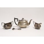 A regency-style three-piece tea service of compressed oval form, each with gadrooned rim & on four