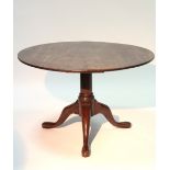 An 18th century mahogany tripod table with circular top, on three cabriole legs with pad feet;