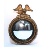 A regency-style gilt framed convex wall mirror with eagle surmount; 20" diam. x 28" high.