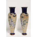 A pair of Royal Doulton stoneware slender ovoid vases of buff ground, with deep blue necks & foot-