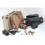 A Minolta “X-300” camera with various accessories; an Agfa camera with leather case; a tan leather