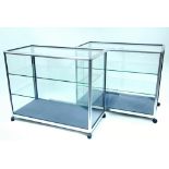 A pair of silvered-metal frame shop china display cabinets, each fitted two plate-glass shelves