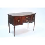 An early 19th century mahogany small bow-front sideboard fitted two small central drawers, a deep
