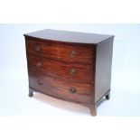 An early 19th century mahogany bow-front chest fitted three long graduated drawers with later