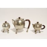 A modernist a three-piece tea service of spherical design, each with hardwood handle & on three “