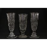 A pair of 19th century tall narrow ale glasses with cut roundels & on short baluster stems, 7½"; & a