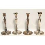 A set of four late 18th century Sheffield candlesticks with round tapered columns on circular