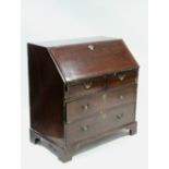 A late 18th century mahogany bureau, the sloping fall front enclosing fitted interior, two short &