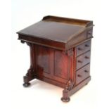 An early Victorian mahogany davenport with sloping hinged top, fitted long pen drawer above three