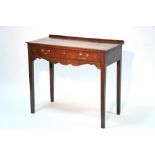 A late George III oak side table fitted frieze drawer above a shaped apron, on square legs; 34"