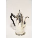 A Queen Anne style coffee pot of plain round tapered form with domed hinged lid & ebonised scroll