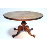 A mid-Victorian figured walnut oval breakfast table on turned & carved centre pedestal & four