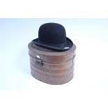 A Devonia black felt bowler hat (Exacta half size); & a grained tin oval hat box.