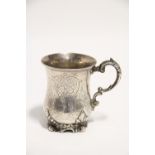 A Victorian engraved baluster mug with cast scroll handle, & on foliate scroll foot, 4¼” high;