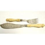 A pair of Victorian engraved fish servers with carved ivory handles; Sheffield 1877, by Fenton