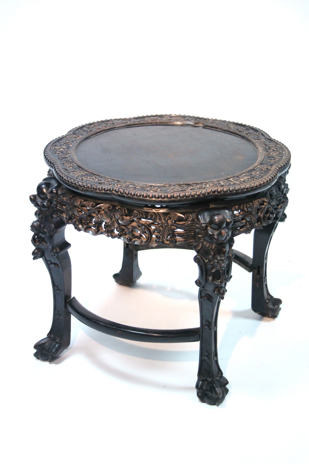 A late 19th century Chinese hardwood circular occasional table with lobed border & all-over carved