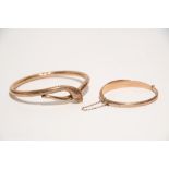 A 9ct. gold circular hollow bangle of serpent design; & a 9ct. gold small oval hollow hinged bangle.