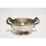 An 18th century Italian circular deep bowl with cast leaf-scroll handles, on round pedestal foot,